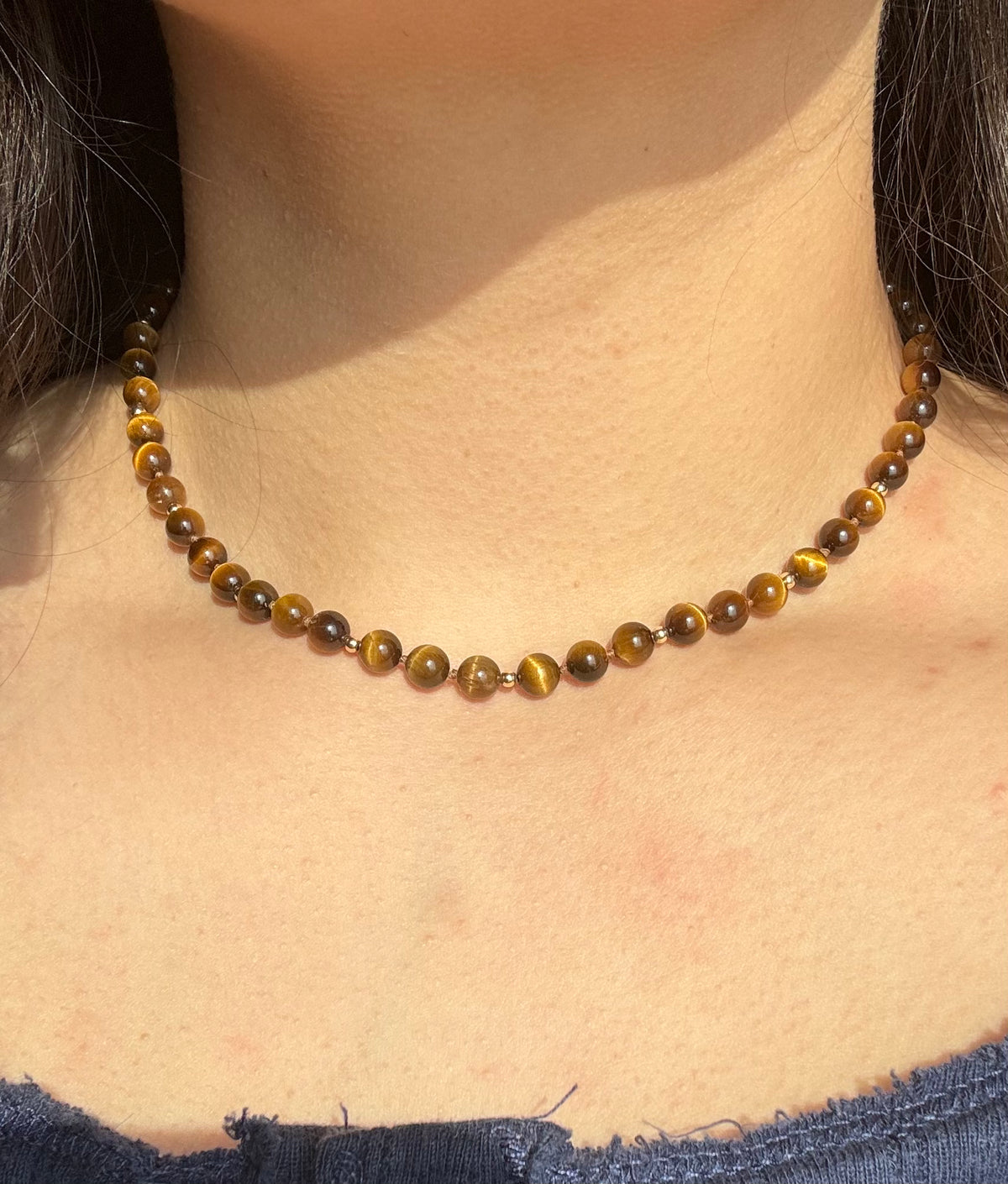 14k solid gold tiger’s eye strand necklace worn on neck showing fit and length