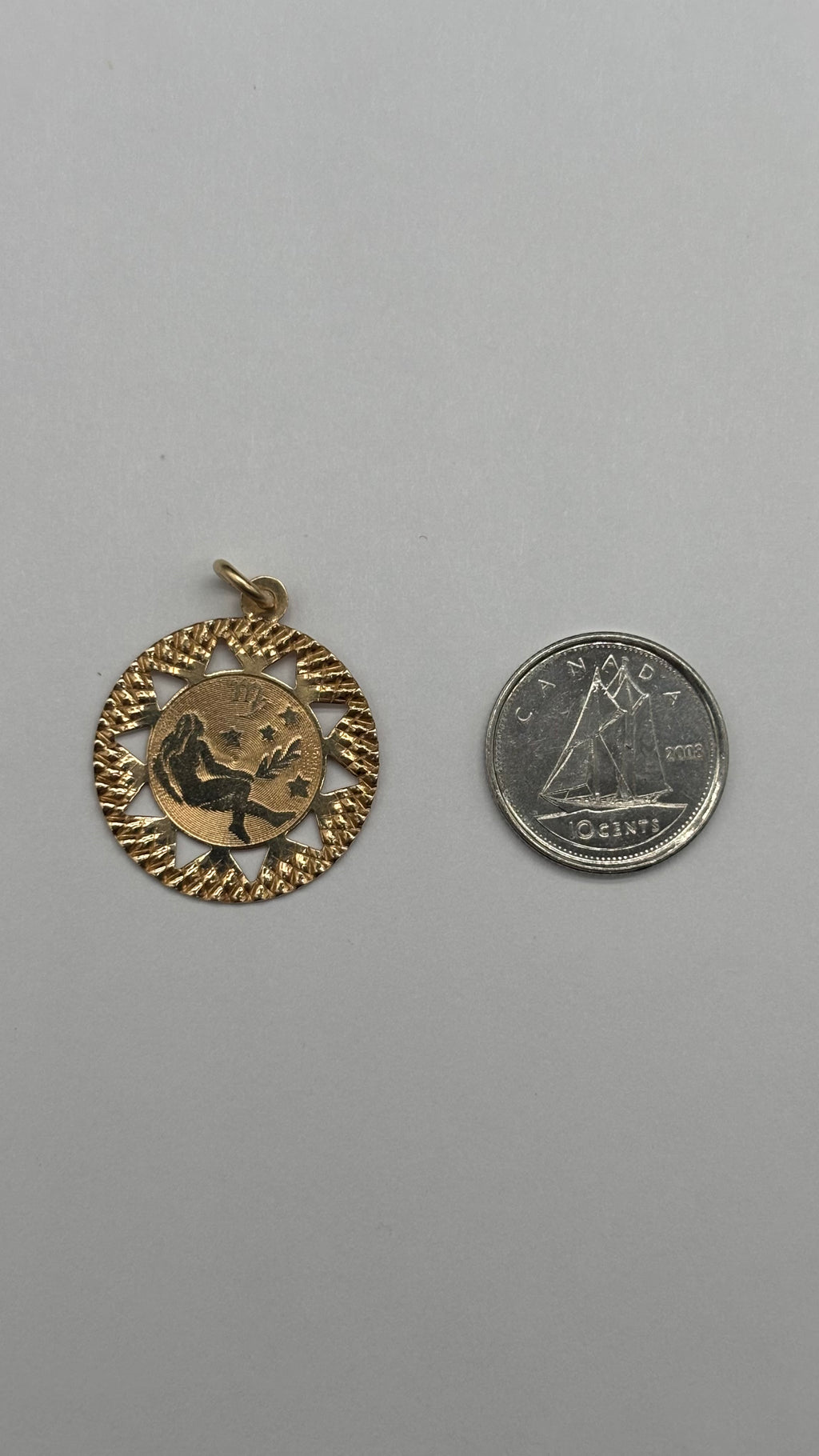 14k solid gold Virgo charm next to Canadian 10 cent coin for size reference