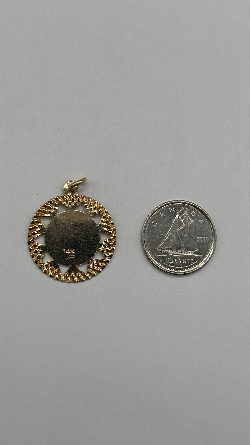 Back of 14k solid gold Virgo charm next to Canadian 10 cent coin