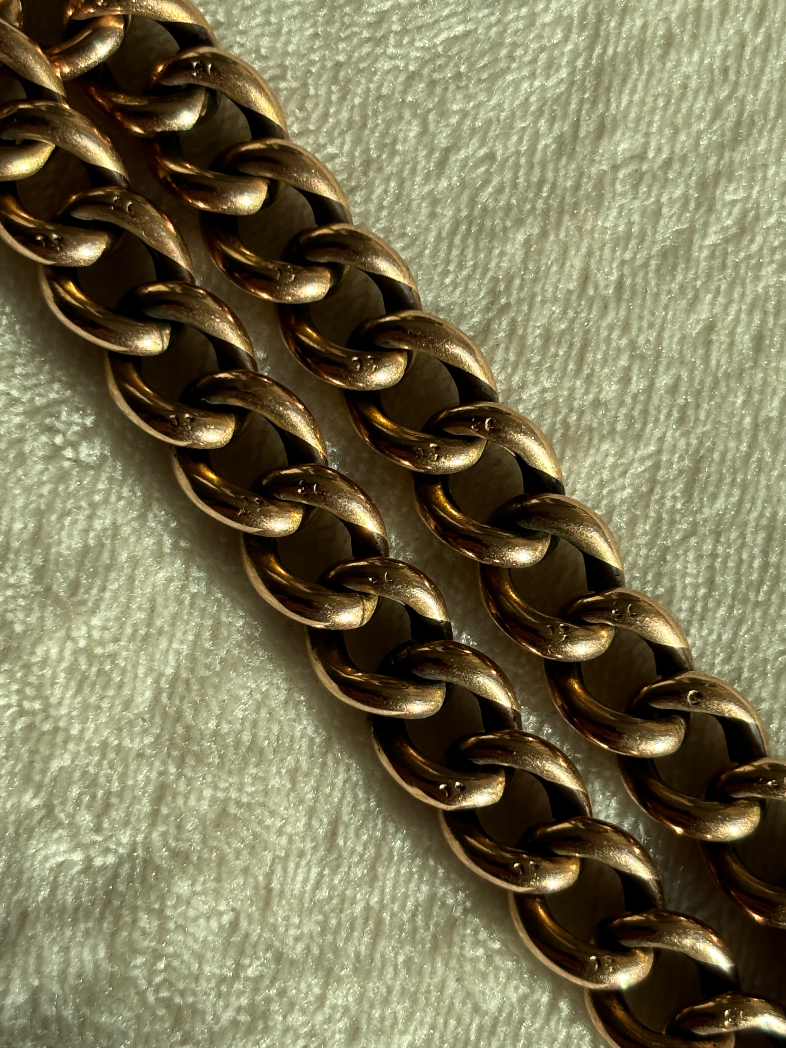 close up of puffy curb links on neutral background in warm sunlight