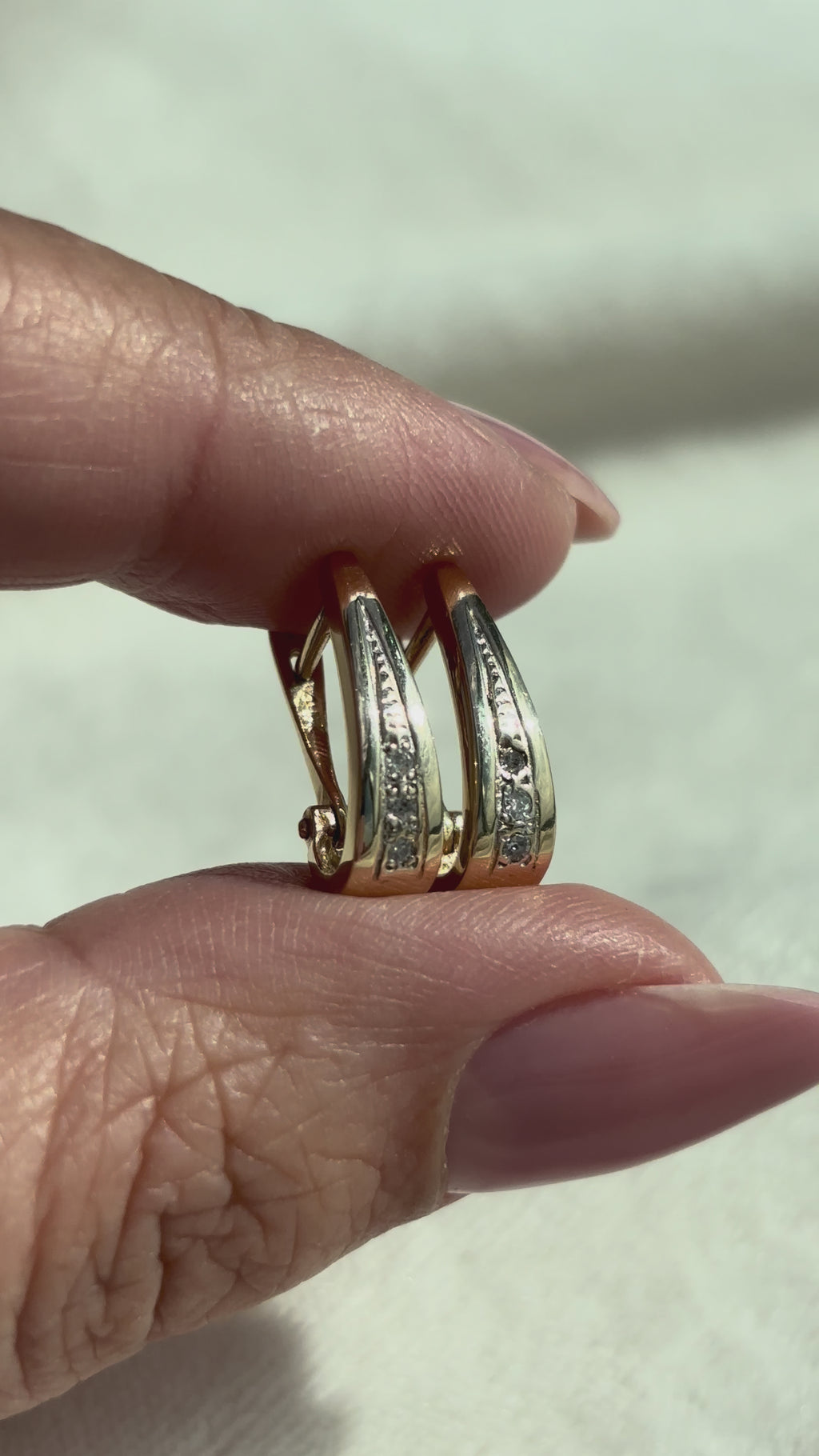 video close-up of 14k Solid Gold Diamond Drop Hoops moving side to side to show condition and shine