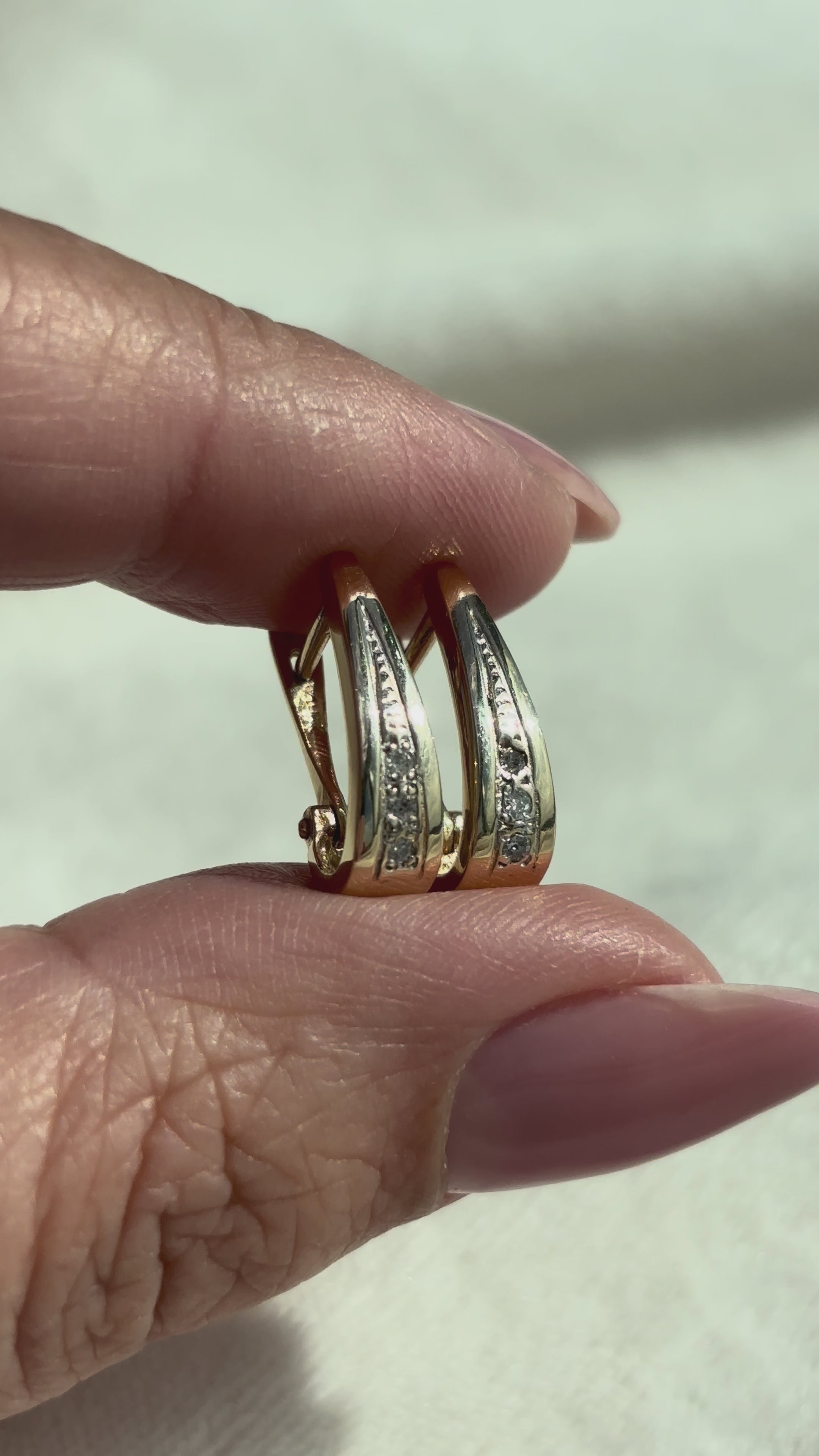 video close-up of 14k Solid Gold Diamond Drop Hoops moving side to side to show condition and shine