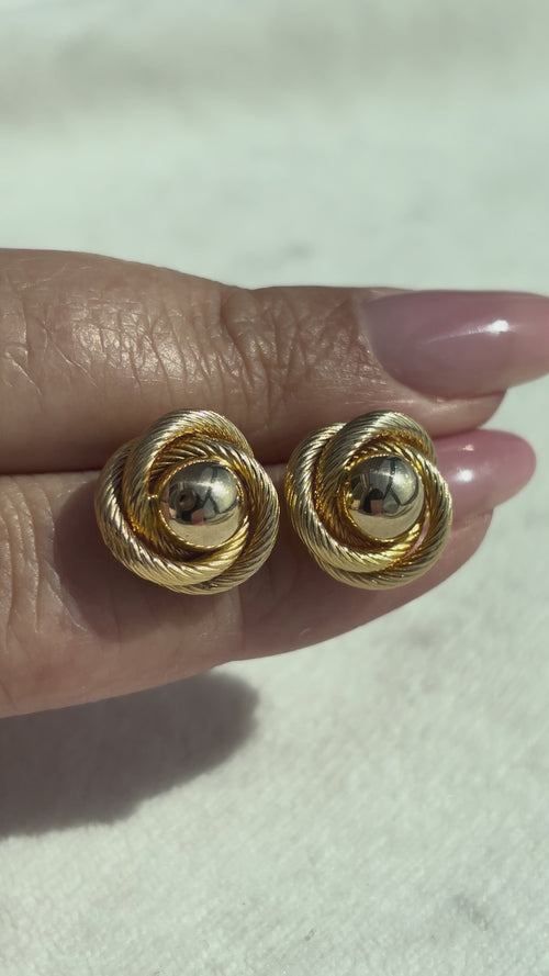close up video of 10k Solid Gold Knot Ball Earrings moving side to side to show shine, condition, and dimension