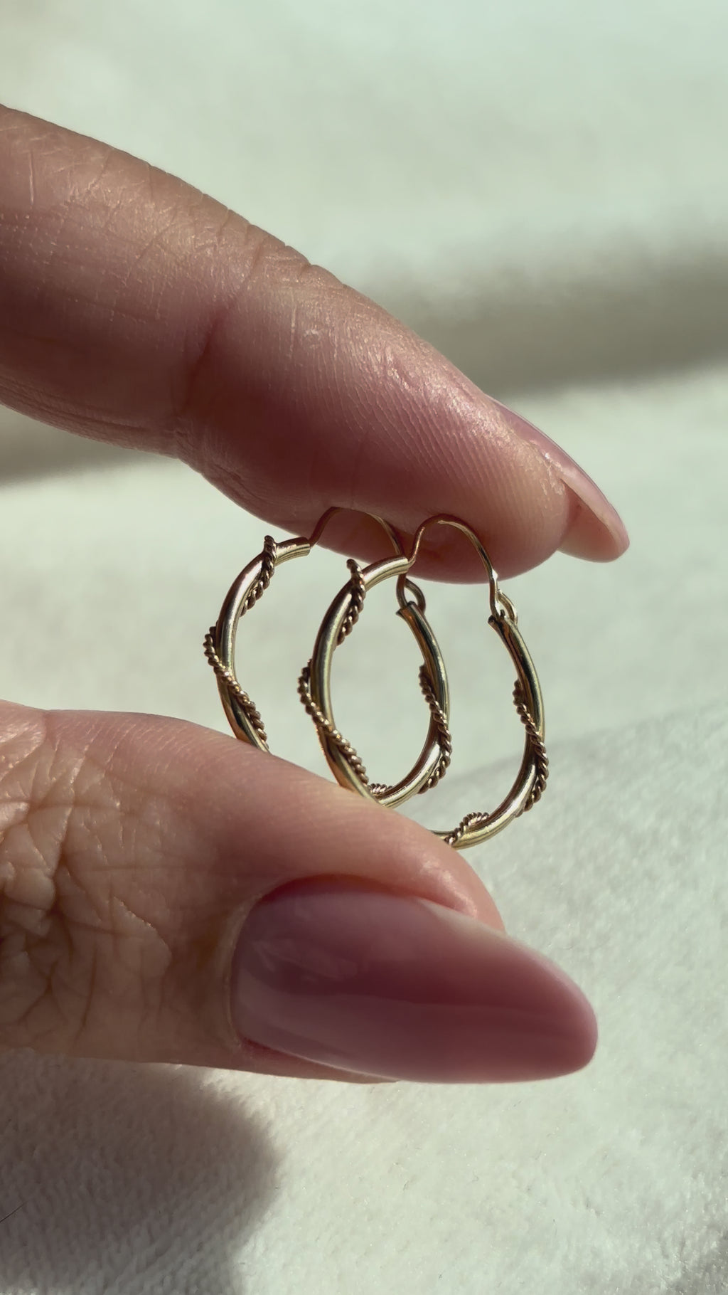 close up video of 10k Solid Gold Twisted Sailor Hoops moving side to side to show shine and condition