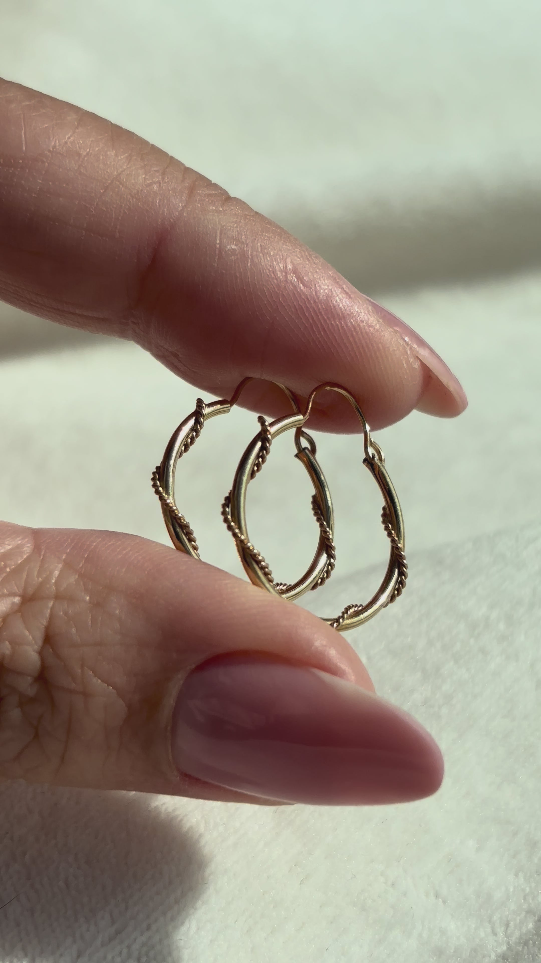 close up video of 10k Solid Gold Twisted Sailor Hoops moving side to side to show shine and condition