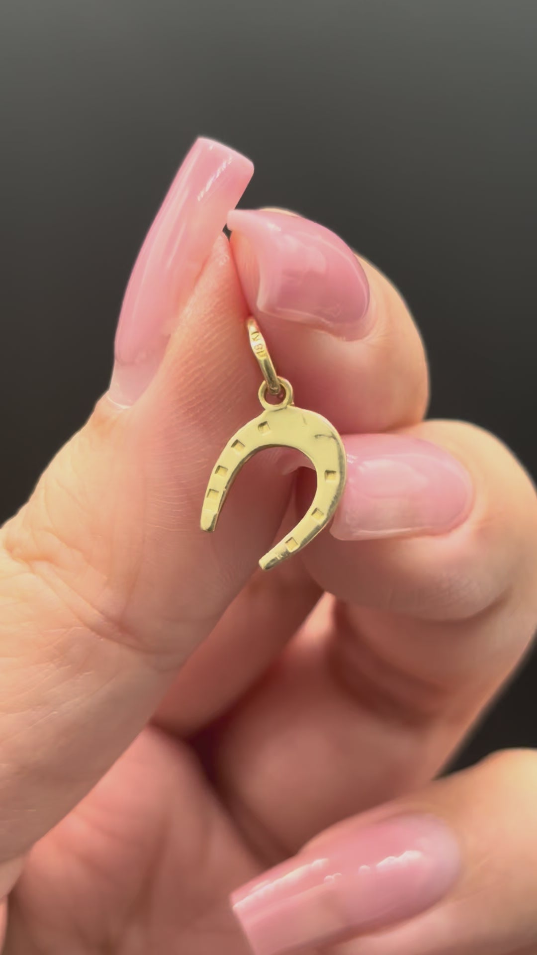 18k solid gold horseshoe charm close-up video showing gold shine and reflection