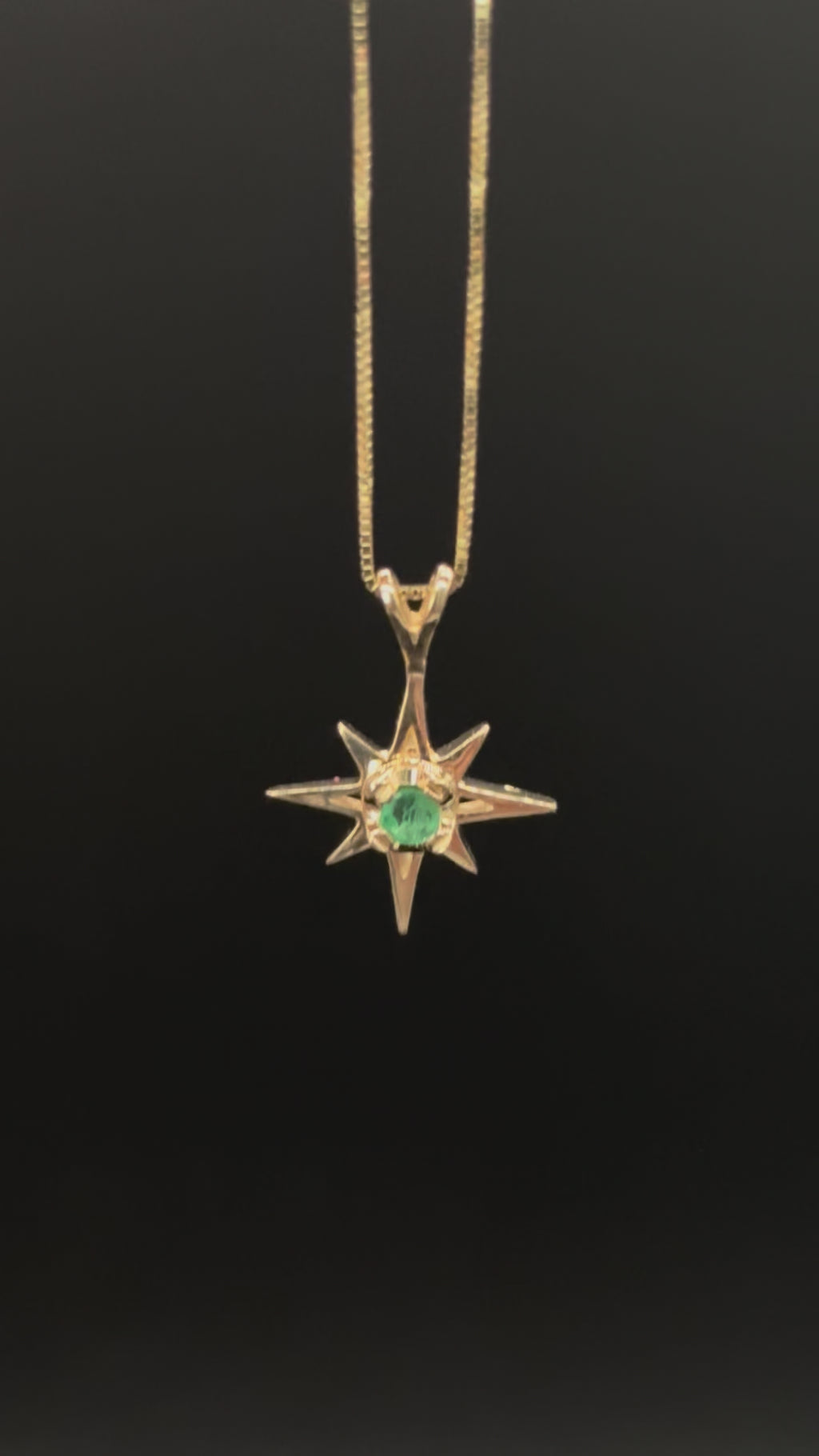 14k solid gold emerald star pendant necklace close-up on box chain showing stone and setting detail