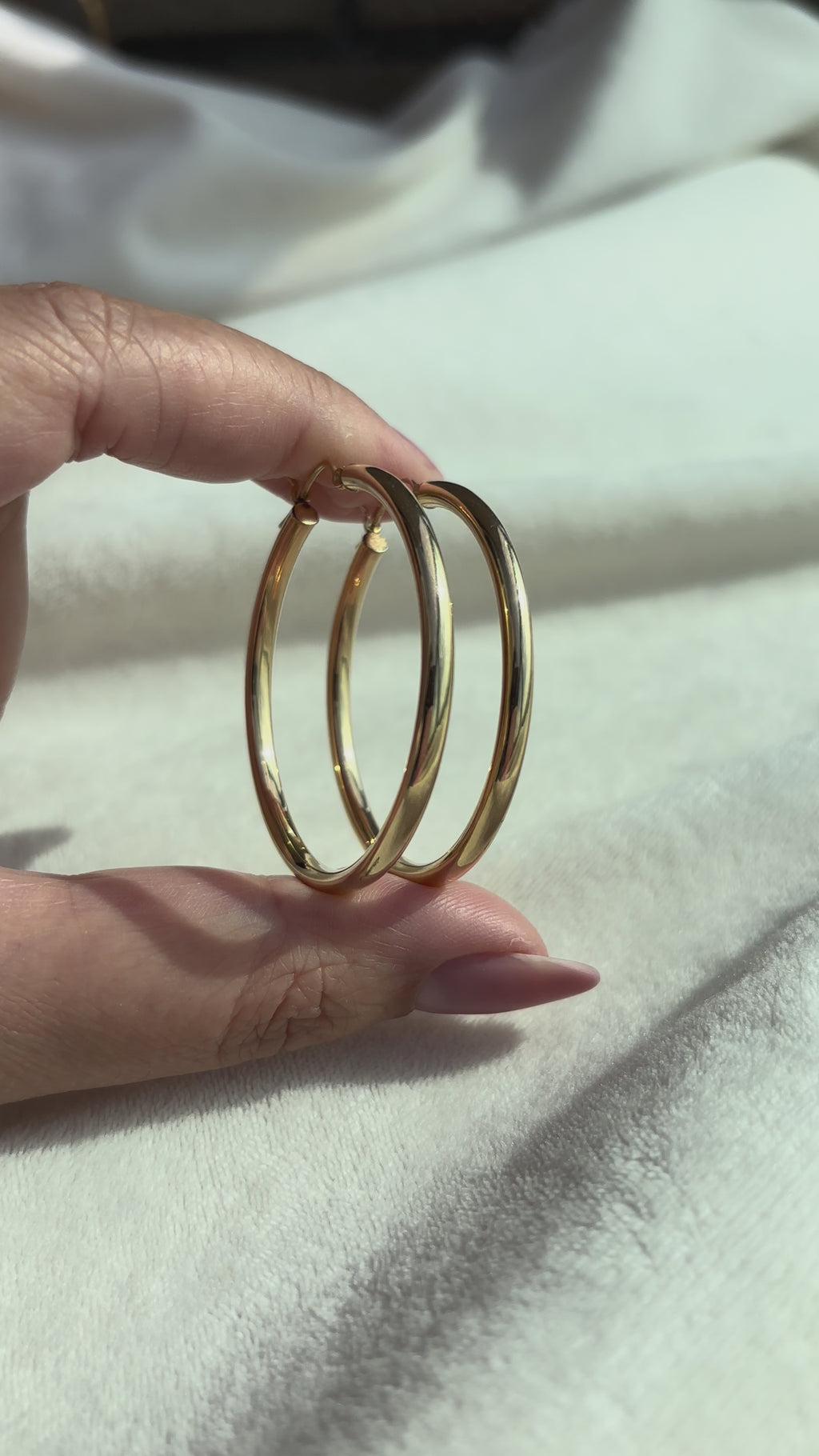 close up video of 14k Solid Gold X-Large Tube Hoops moving side to side to show condition and shine