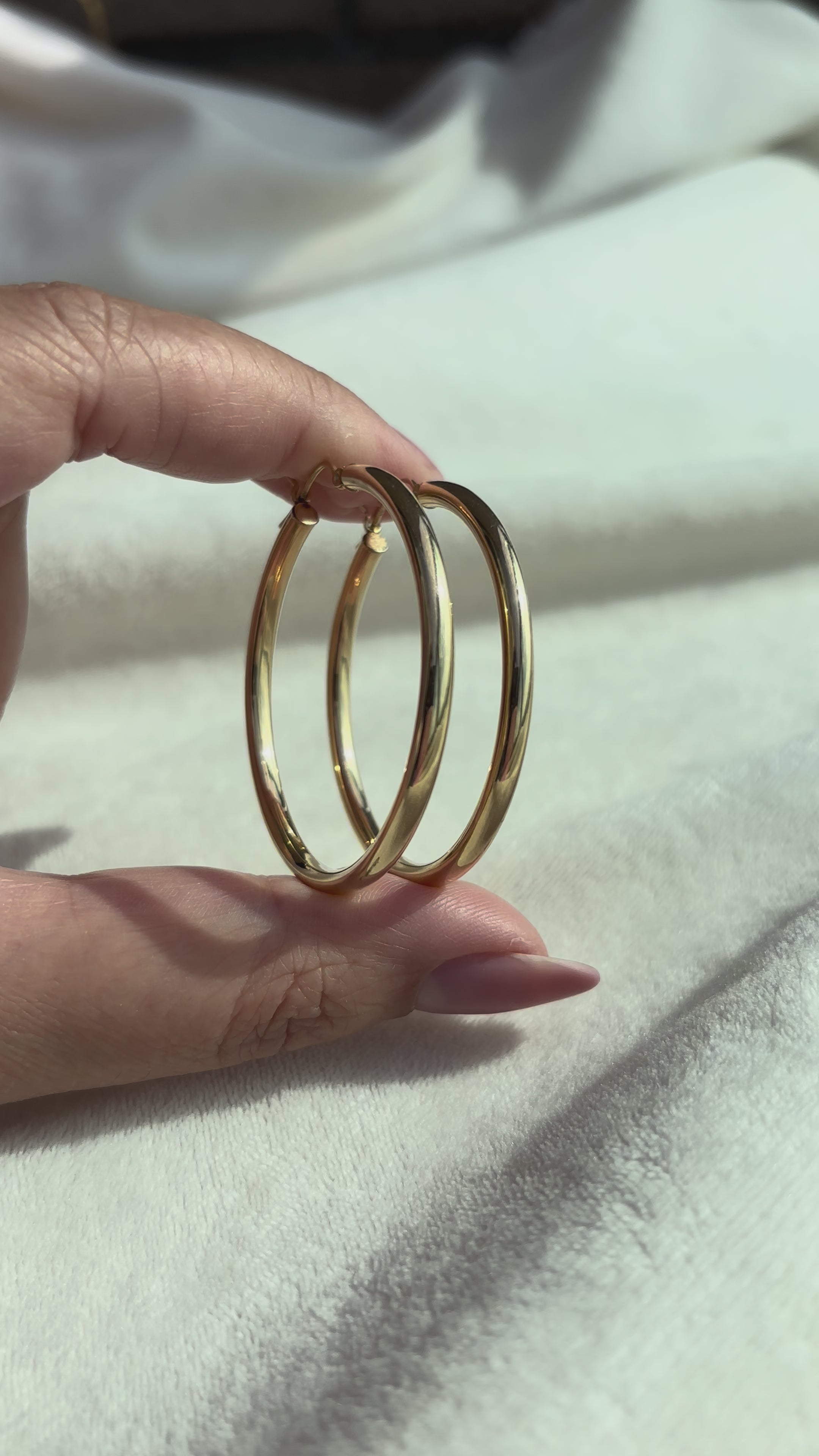 close up video of 14k Solid Gold X-Large Tube Hoops moving side to side to show condition and shine